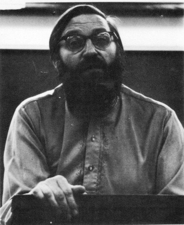 A younger, more serious, Harry at the podium delivering a lecture.